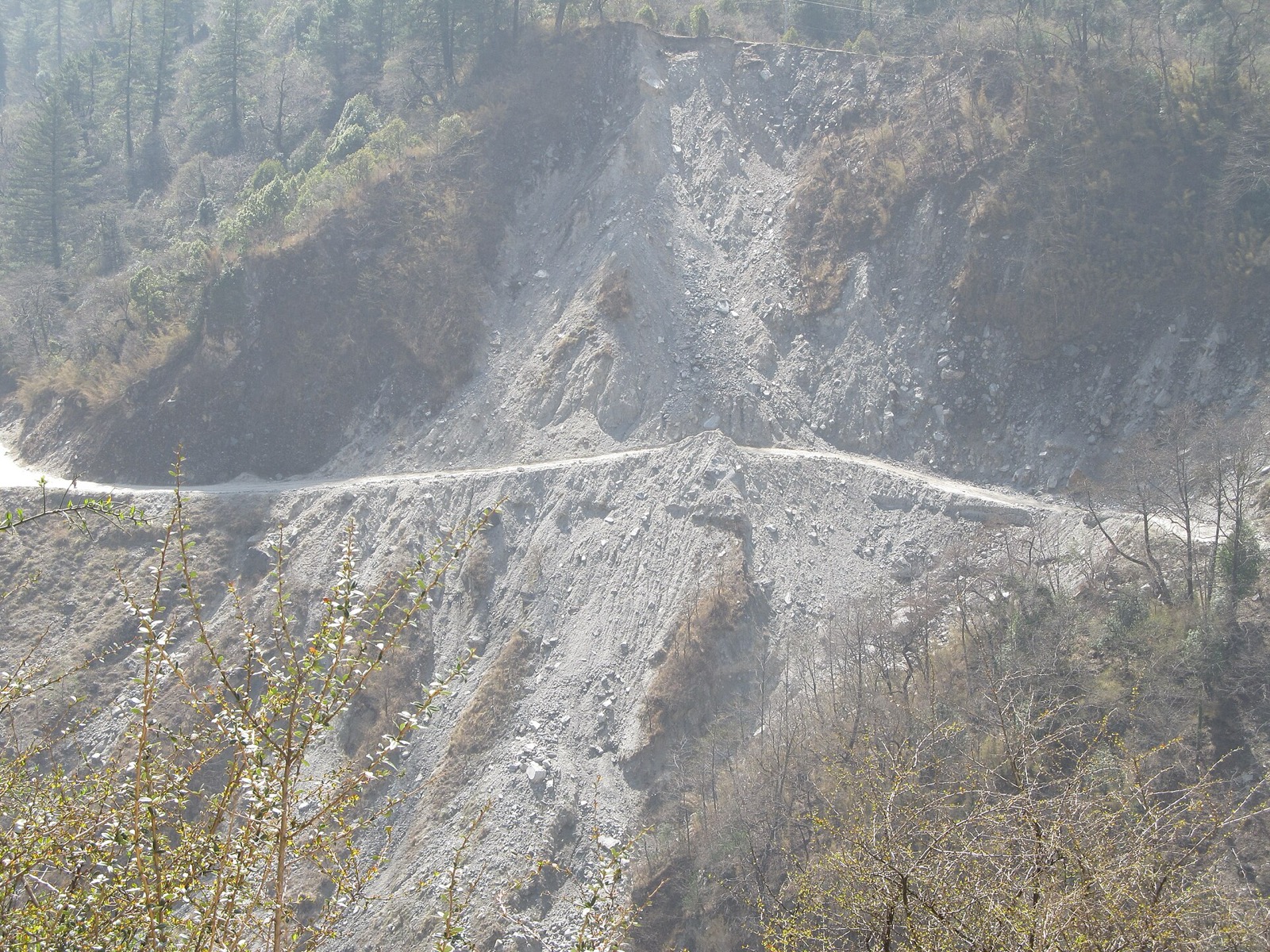 A narrow road cut into a steep hillside in the Kali Gandaki valley