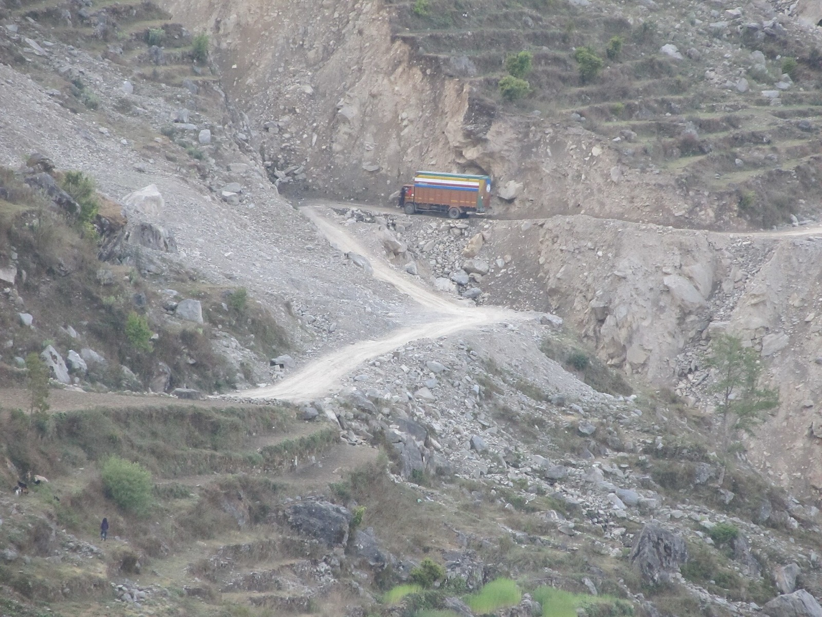 A truck driving up a hill road past a landslide near Thulogaon on the Trisuli road