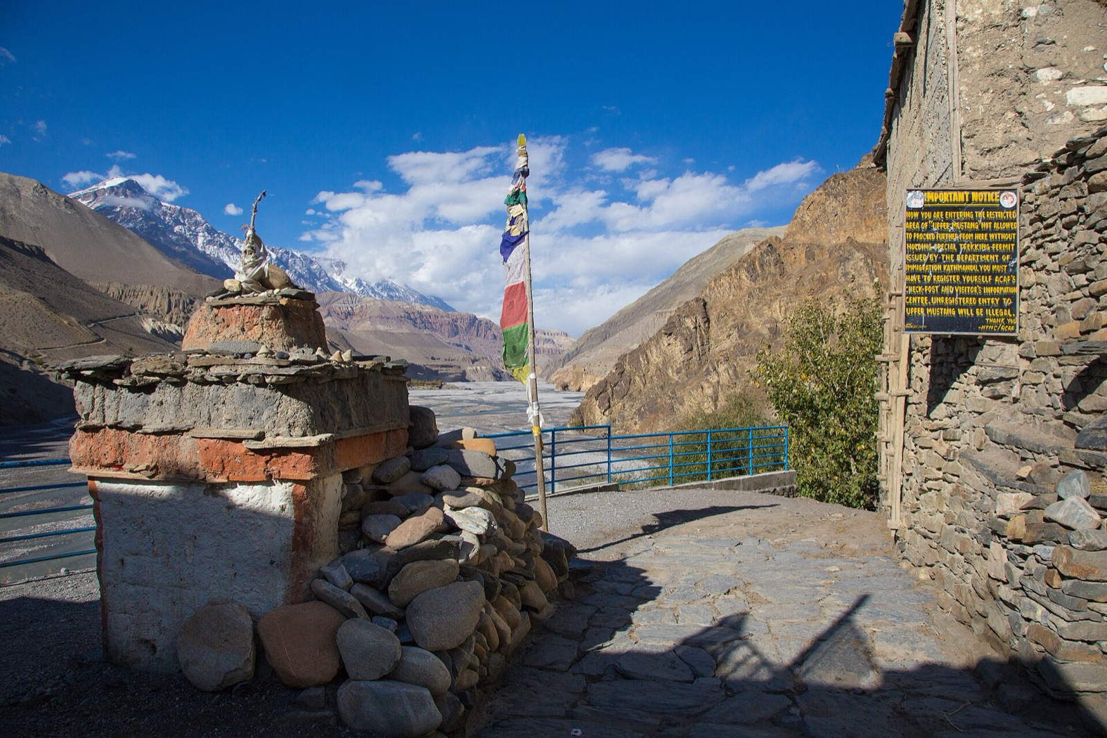 A roadside notice sign marking the entrance to the restricted area of Upper Mustang, which requires a special trekking permit